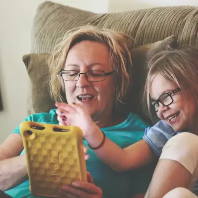 Carer/Parent with young girl looking at tablet