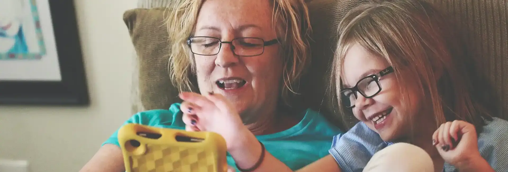 Carer/Parent with young girl looking at tablet