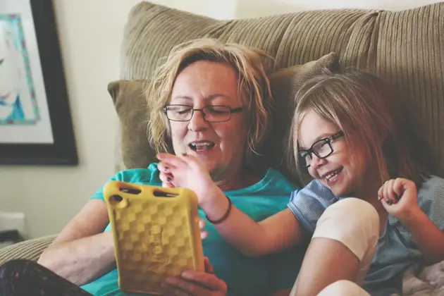 Carer/Parent with young girl looking at tablet