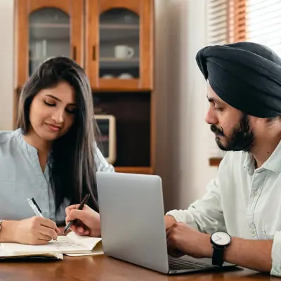 Asian Couple with Laptop in Kitchen